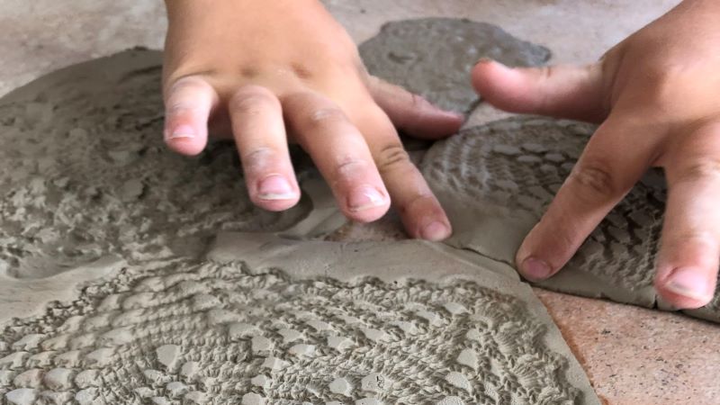 Barn skapar mönster i lera