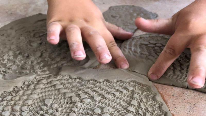 Barn skapar mönster i lera